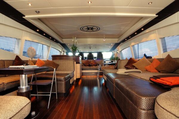 Spacious main salon with sofas and dining area on board Mangusta 108 luxury yacht in Costa Smeralda, Sardinia