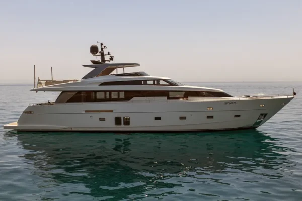 Elegant port side view of the Sanlorenzo 96 yacht anchored in the calm waters of Porto Cervo, Sardinia during the late afternoon.
