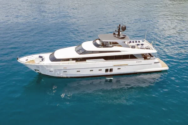 Complete side profile of the 29-meter Sanlorenzo 96 yacht at anchor in the crystal clear waters of Sardinia.