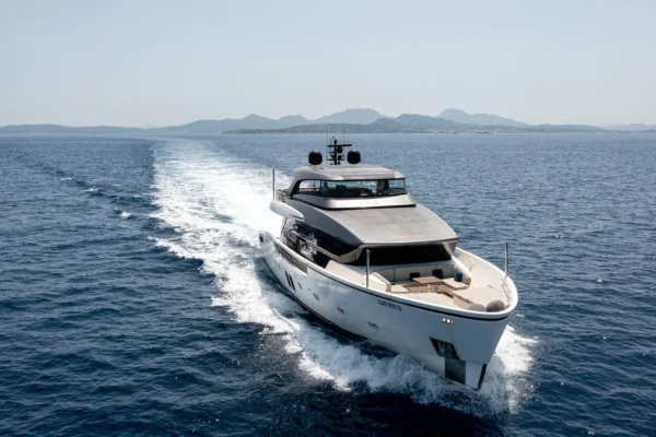 Front starboard view of the Sanlorenzo SX88 motor yacht cruising through the ocean, leaving a large white wake behind its hull.