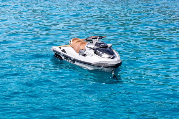 White and grey Sea-Doo personal watercraft floating on clear blue ocean water.