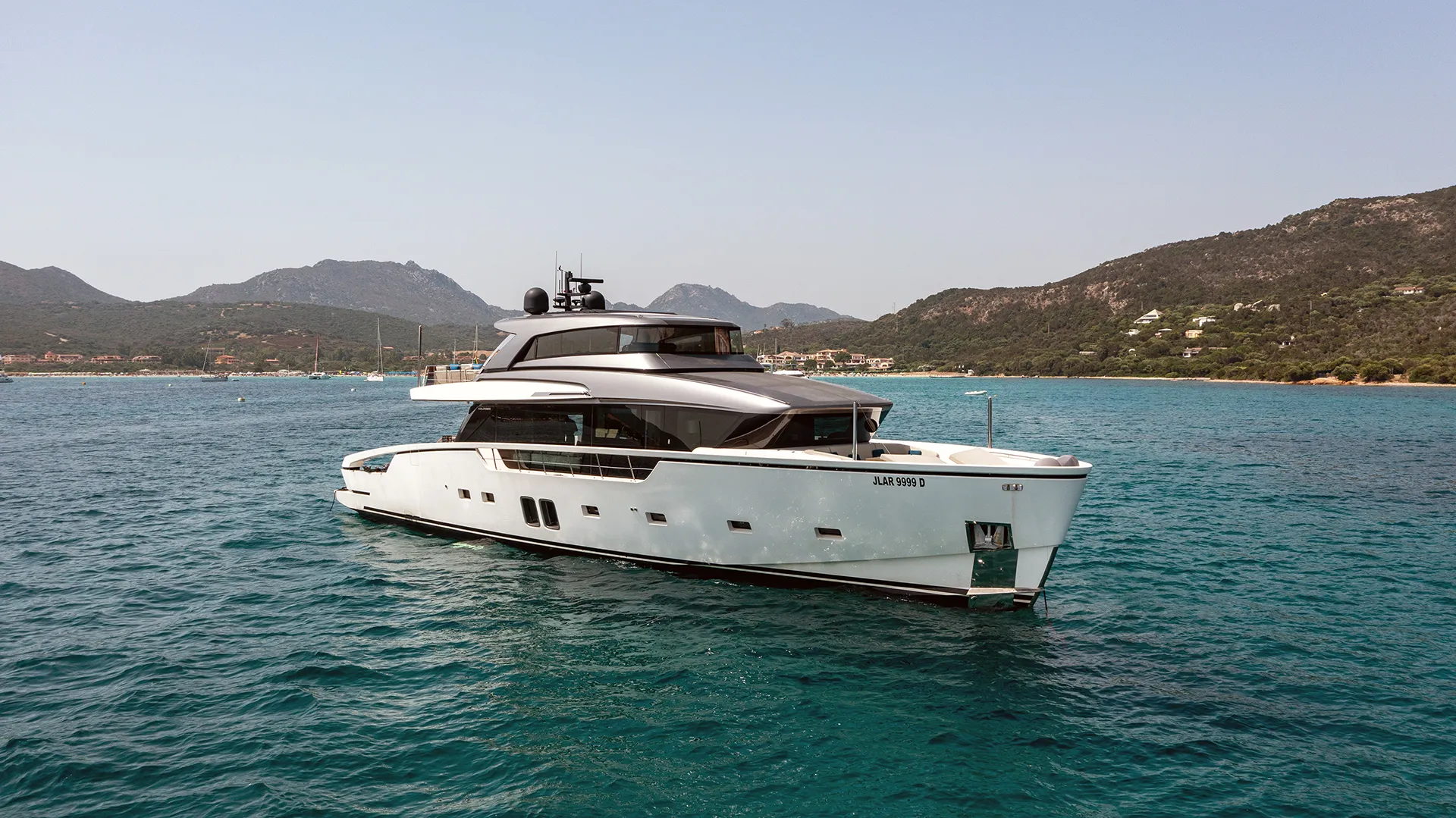 Sanlorenzo SX88 Starboard Side Exterior Profile Port side profile of the Sanlorenzo SX88 motor yacht floating on clear blue water, displaying its distinctive hull lines, large glass panels, and dark grey superstructure.